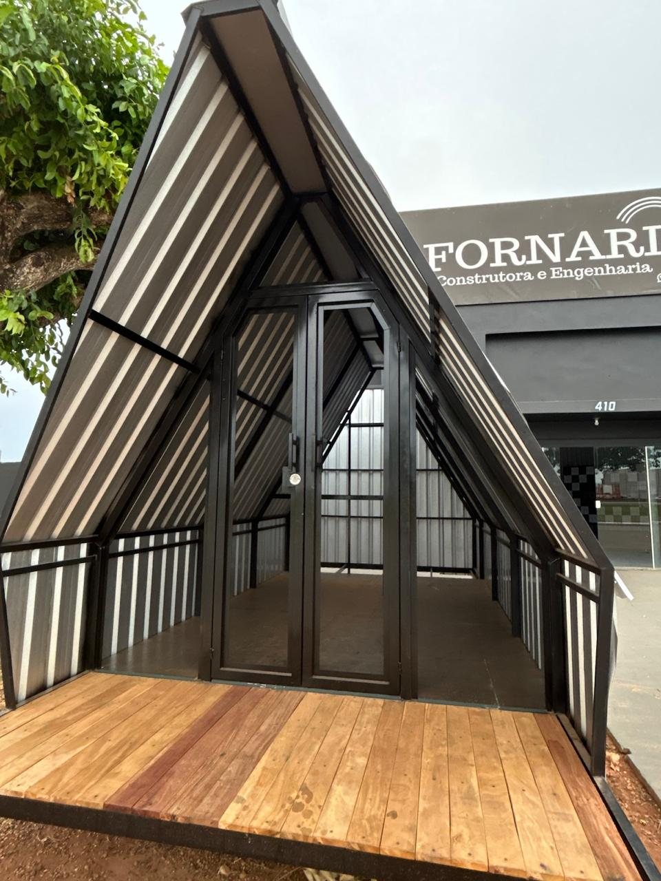 Chalé em estrutura metálica com deck de madeira, em frente à sede da Fornari
